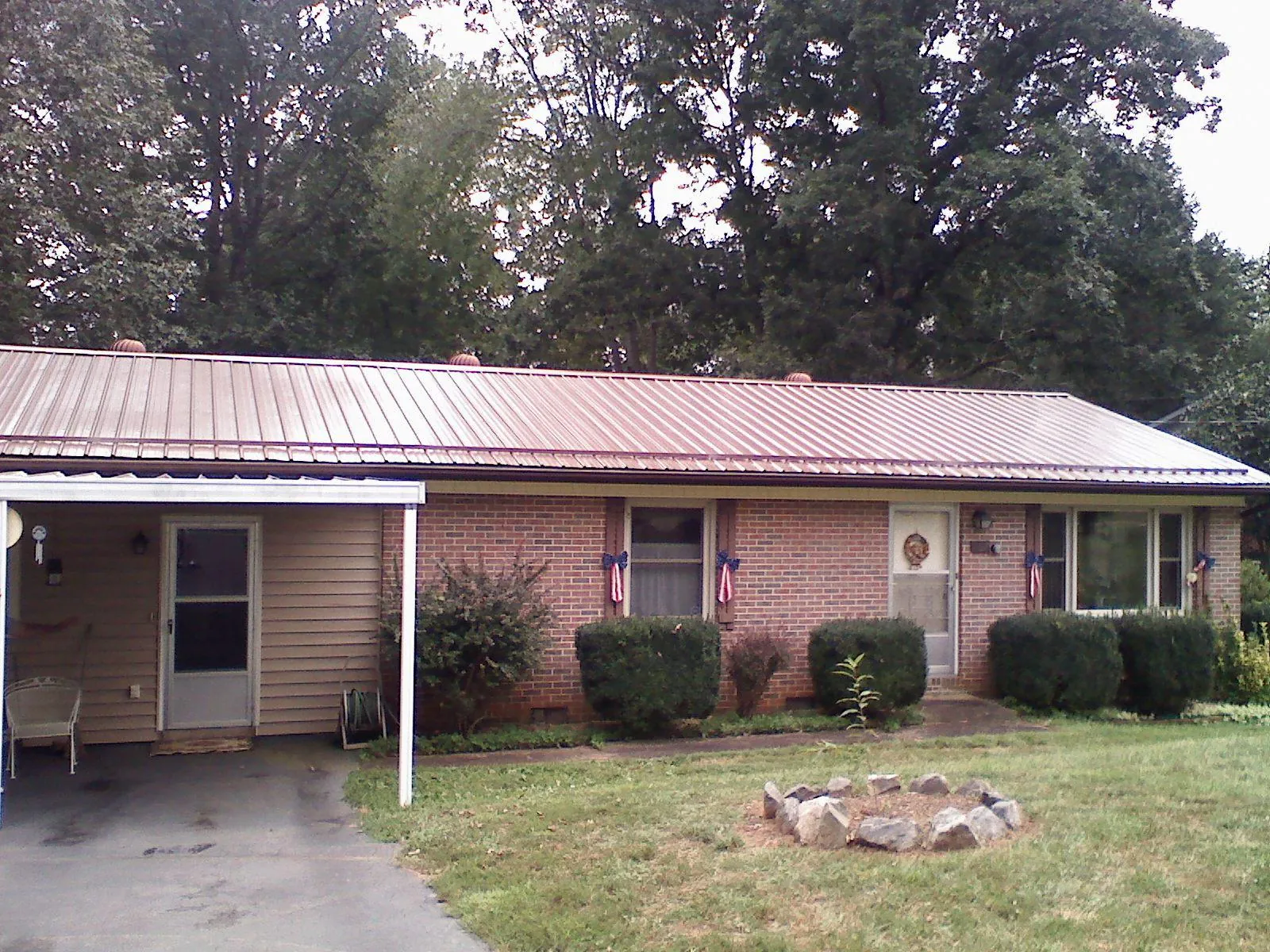 Bronze metal roof and carport on a brick ranch home — Roof Repair work by our crew in Ama